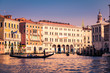Typical Venetian gondola leaves for a sightseeing tour at sunset.