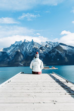 Woman Sitting On Dock Front Of Ice-capped Mountain
