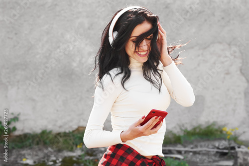 Young Happy Sportive Woman In Urban Background Listening