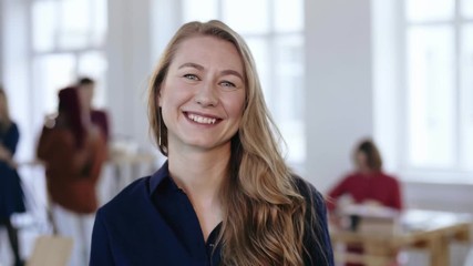 Wall Mural - Close-up portrait of happy professional female boss with blond hair in formal clothes posing at trendy modern office.