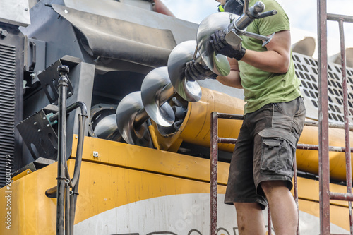 Fotomural The mechanics repair the yellow and green combine harvester in the farm yard