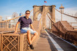 Tourist model posing for photo taking on a Brooklyn Bridge