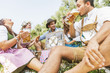 Five friends having fun on Bavarian RIver and clinking glasses with Oktoberfest beer