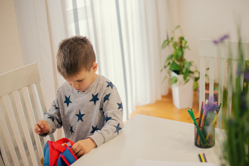 The little boy is doing homework.