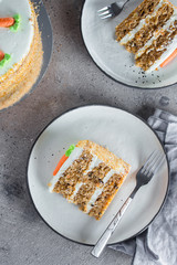 Wall Mural - Slice of homemade carrot cake with cream cheese frosting on plate on gray stone table background