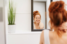 Happy Young Woman Grinning At Her Reflection