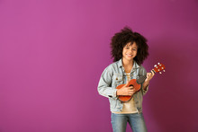 African-American Girl With Guitar Against Color Background