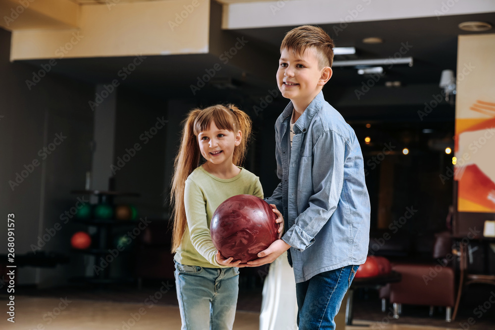 Little children playing bowling in club