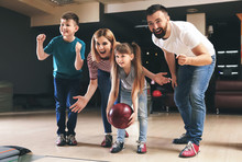 Family Playing Bowling In Club