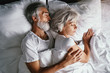 © luengo_ua - Senior family couple sleeping together in bed.