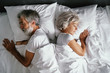 © luengo_ua - Senior family couple sleeping together in bed.