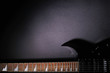 © Iryna - Top view of electric modern black guitar on a black background with copy space