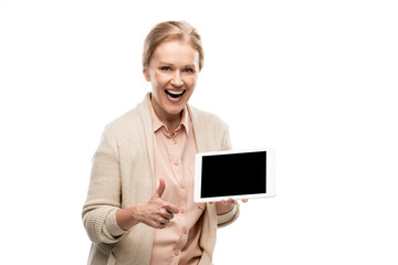 Wall Mural - excited middle aged woman doing thumb up sign and holding Digital Tablet with blank screen Isolated On White