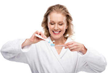 Wall Mural - middle aged woman with toothbrush and toothpaste Isolated On White