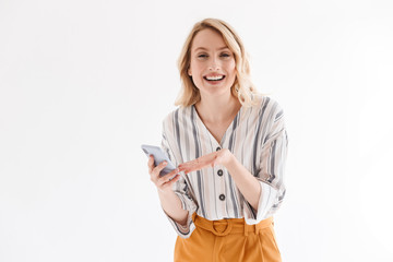 Sticker - Photo of caucasian blond woman wearing casual clothes smiling at camera and pointing on smartphone