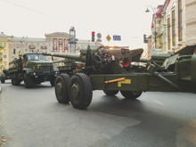 Toned Image Of Big Cannon And Military Trucks Riding On City Street During War Parade