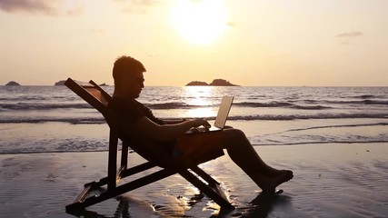 happy freelancer with laptop computer working on the beach, freelance work concept, dream office job workplace