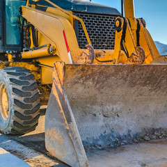 Clear Square Close up of the dirty bucket of a loader parked on the road on a sunny day