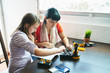 © Per Swantesson/Stocksy - Young adult woman teaching a teenager science and robotics