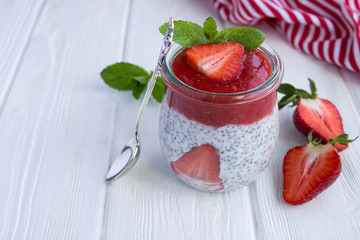 Wall Mural - Pudding with chia and strawberry on the white wooden background
