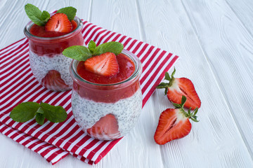 Wall Mural - Pudding with chia and strawberry on the white wooden background