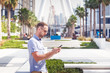 © vladdeep - Young man in eyeglasses using his phone in Dubai