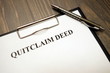 Clipboard with quitclaim deed on desk