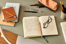 Notebook With Handwritten Text, Pencil And Glasses On Desk.