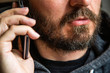 © ilijaa - Close up portrait of bearded man talking on smart phone, focus on lips, no eyes, secret talk, criminal threating someone