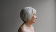 © Rob and Julia Campbell/Stocksy - Senior topless woman on simple grey background