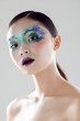 © Julia K/Stocksy - Beautiful model posing in a studio with glitter makeup