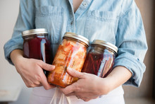 Woman Holding Various Jars Of Fermented Food