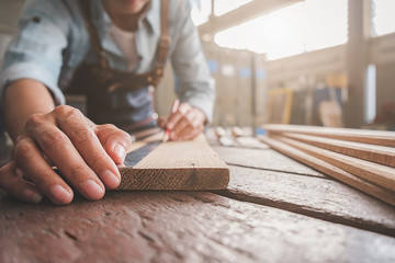 Carpenter working with equipment on wooden table in carpentry shop. woman works in a carpentry shop.