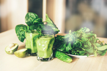 Glasses with freshly prepared green smoothies on the table, healthy lifestyle concept