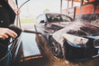 © Fxquadro - Smart trendy man in jeans and blaser is washing his own car at car washing station.