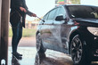 © Fxquadro - Busy man in jeans and blaser is washing his own car at car washing station.