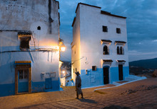 Young Woman Exploring An Old Blue Town