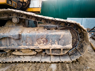 Closeup image of dirty excavator tracks on the building site