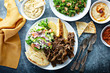 © fahrwasser - Mediterranean food on the table, gyro platter, pita and dips and tabbouleh