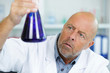 © auremar - senior scientist holding flask in chemical lab