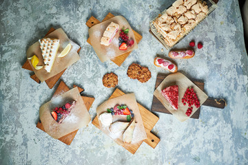 Assorted sweet desserts. Top view. Gray textured background. Beautiful serving dishes. Dessert. Food chain