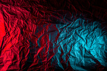 Texture Of Crumpled Black Paper. Close Up Black Background Of Crumpled Cardboard Under Color Red And Blue Studio Light
