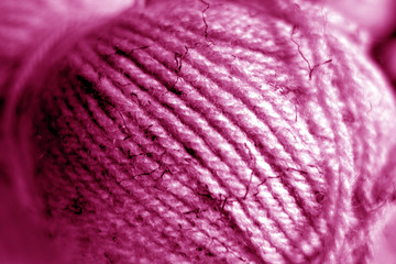 Wall Mural - Yarn ball close-up with blur effect in pink tone.