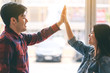 © Farknot Architect - A young couple putting their hands to make high five to each other