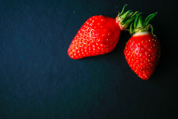 Two delicious strawberrys on black background