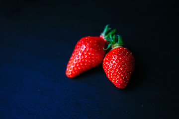 Two delicious strawberrys on black background