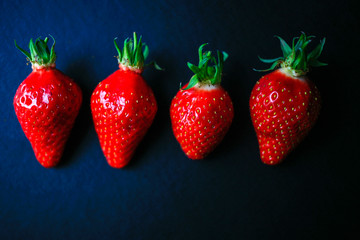 Four delicious strawberrys on black background