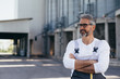 © cherryandbees - worker standing crossed arms, blurred grain silo in background
