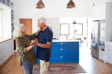 Wall Mural - Senior Couple At Home Dancing In Kitchen Together