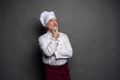 © opolja - Image of chef planing what to cook on gray background.Chef thinking.